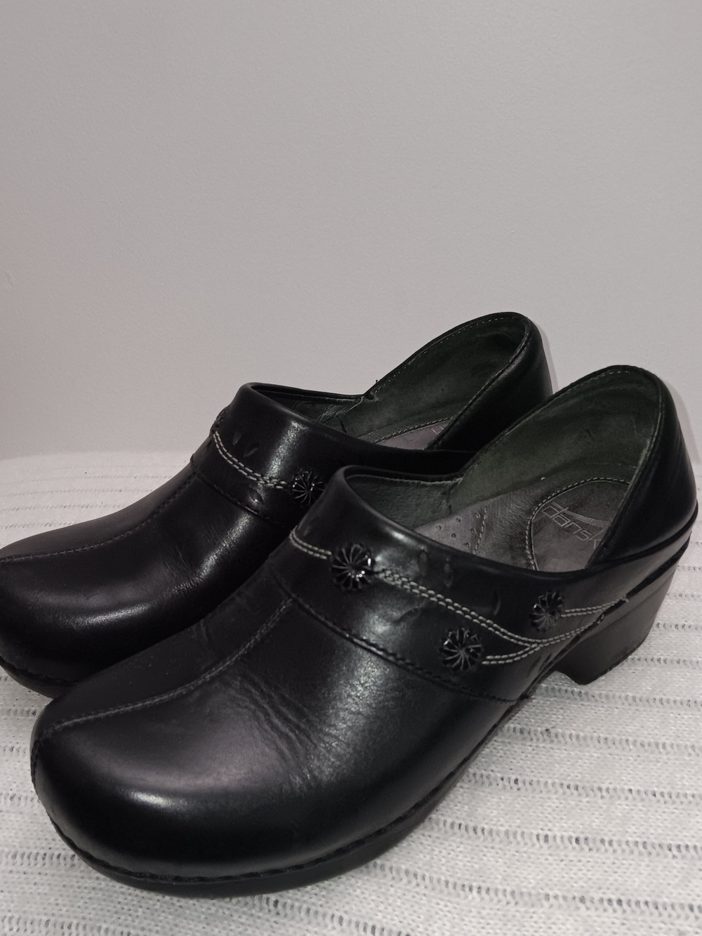 Dansko Black Leather Slip-On Clogs with Floral Accent